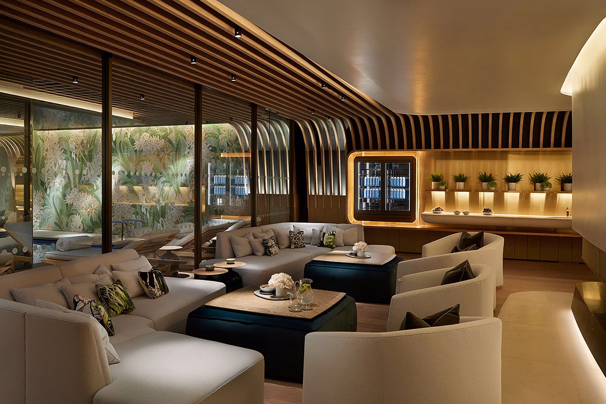 Der exklusive Ruhebereich im Spa des 45 Park Lane mit geschwungenen, hellgrauen Sofalandschaften, samtigen Hockern, einer eleganten Kaffeestation im Hintergrund und einer Glaswand zum Poolbereich