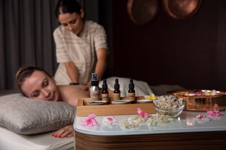 Eine Frau liegt auf dem Bauch und bekommt eine Massage mit Harzöl