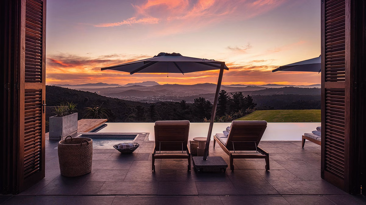 Pooldeck der Owners Villa des Delaire Graff Estate bei Sonnenuntergang