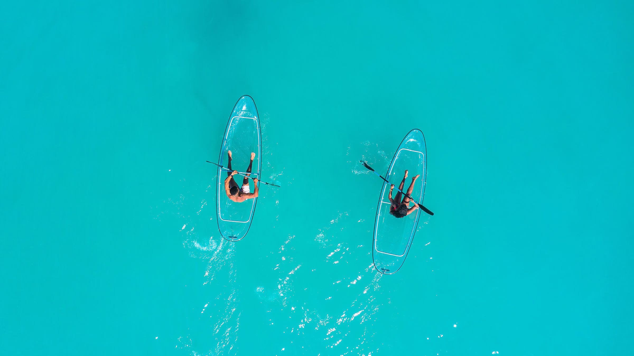 Transparente Kanus im türkisfarbenen Wasser in der Karibik