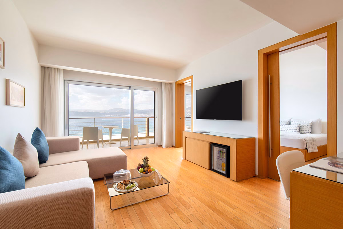 Executive Deluxe Suite des Kempinski Hotel Aqaba Red Sea mit Sofa, Fernseher und Blick auf das Meer