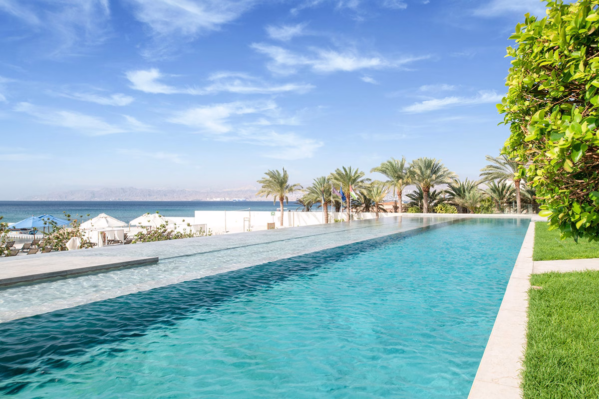 Langer Pool des Kempinski Hotel Aqaba Red Sea mit Blick aufs Meer