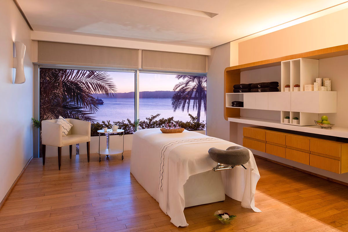 Spa mit einer Massageliege und Blick auf das Meer im Kempinski Hotel Aqaba Red Sea