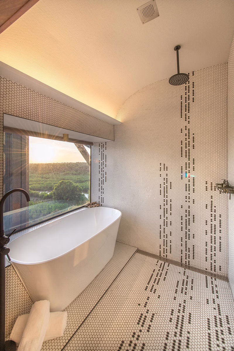 Dusche und Badewanne mit Ausblick des Kruger Shalati