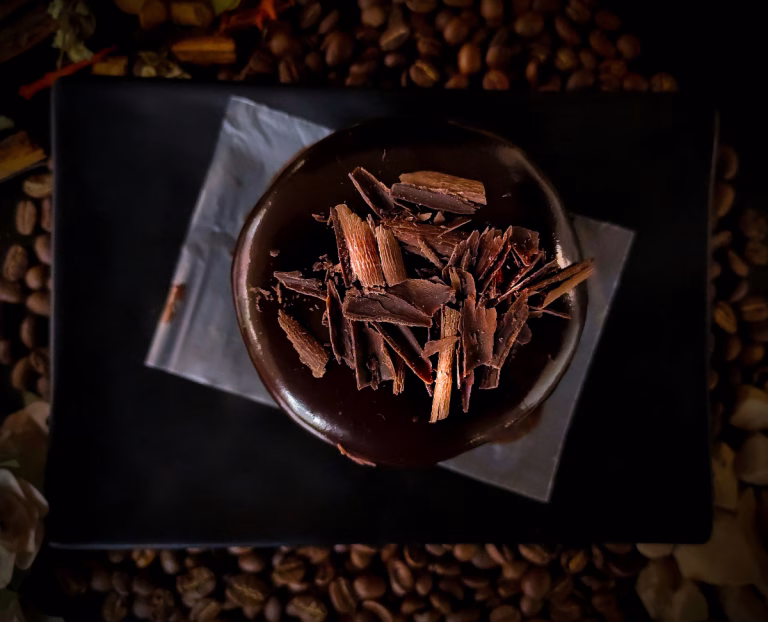 Schüssel mit Schokolade steht auf Kakaobohnen