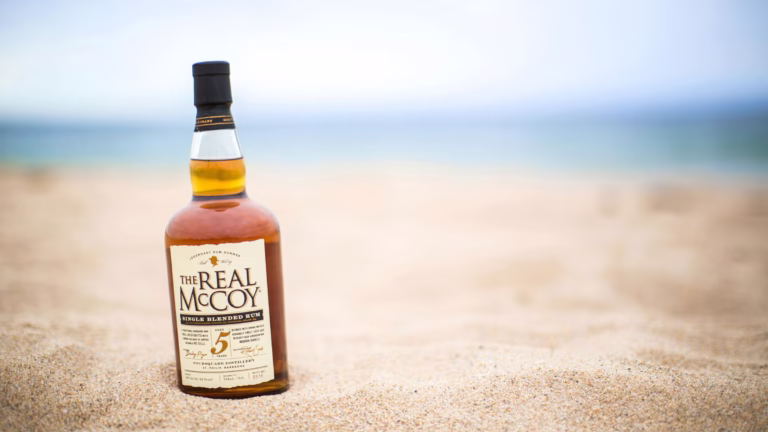 Rumflasche im Sand auf Barbados