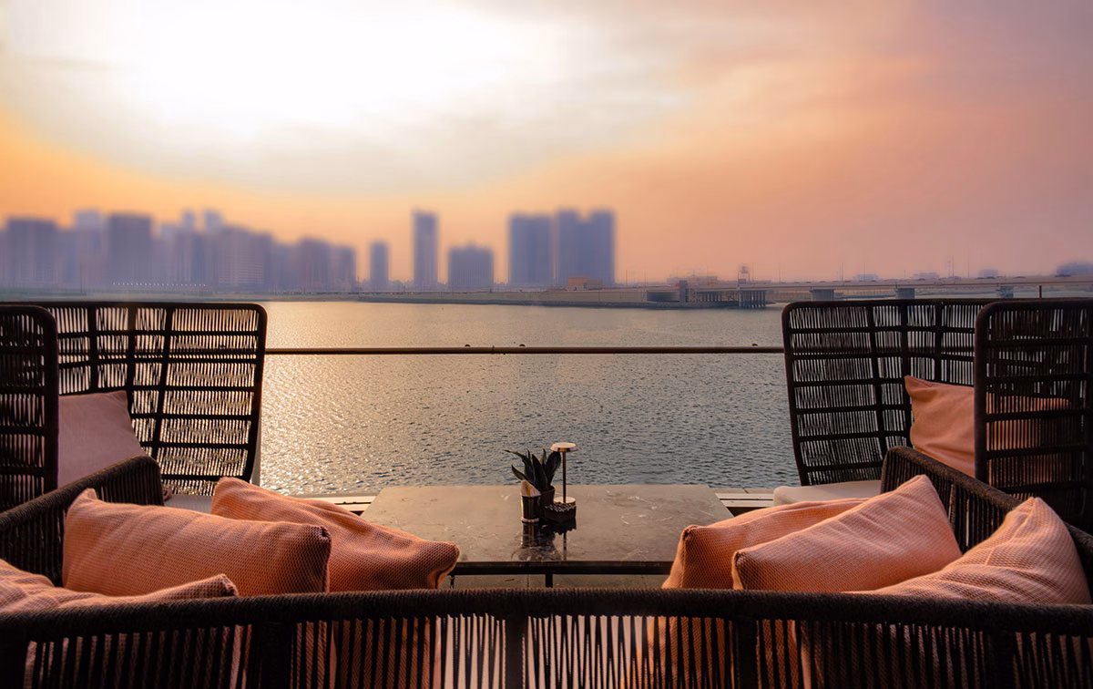 Hidden Bar des Rosewood Abu Dhabi mit Sonnenuntergang über der Metropole mit Blick in die Ferne