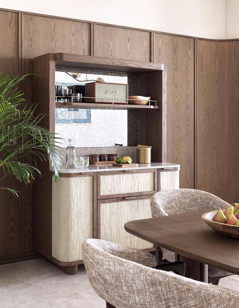 Hochwertig gestaltetes Sideboard der Horizon Suite aus dunklem Holz, bestückt mit einem Marshall-Lautsprecher und Bar-Utensilien, daneben ein eleganter Esstisch mit gepolsterten Stühlen