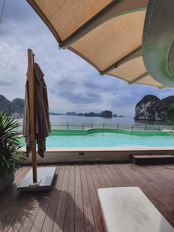 Pooldeck der Bhaya Soul mit Poolliege, Schirm, Pflanze und Blick auf die Kalksteinfelsen