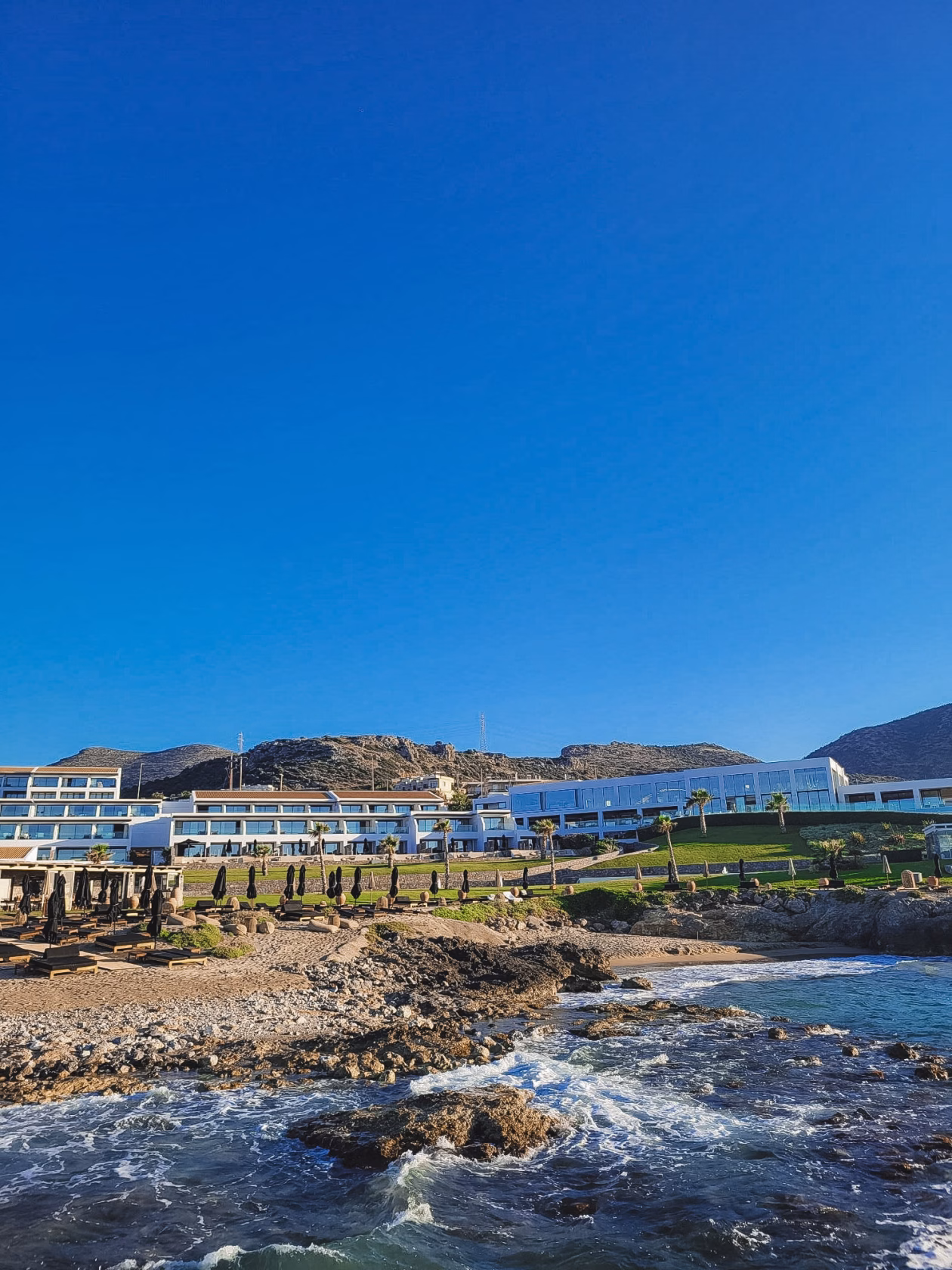 Aussicht vom Meer auf die Klippen und das Resort Abaton Island Resort auf Kreta