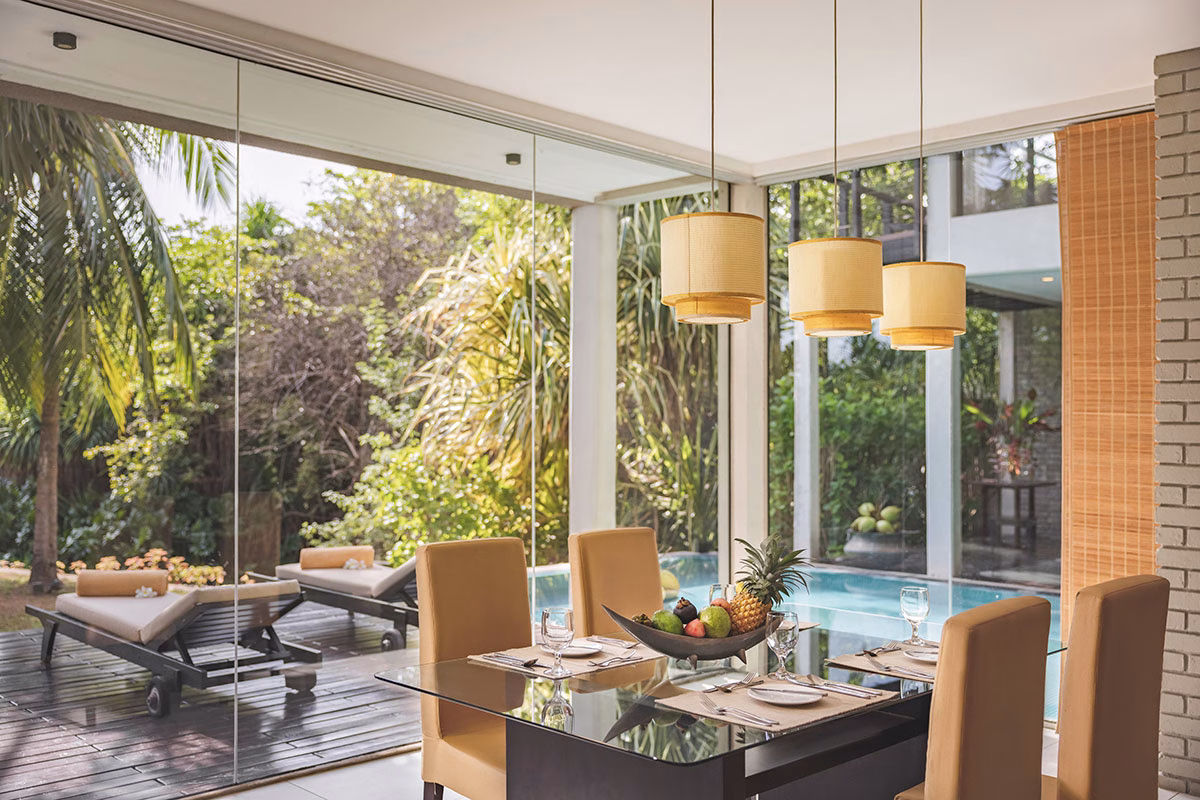 Esszimmer mit Blick auf die Terrasse und den Pool umgeben von wunderschönen Pflanzen