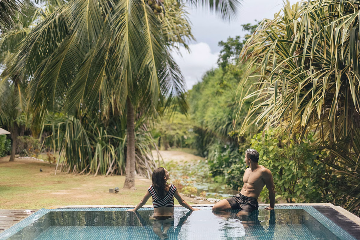 zwei Menschen sitzen im Pool umgeben von der wunderschönen Natur