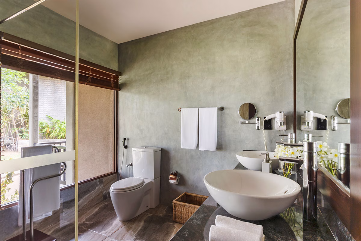 Badezimmer mit Toilette zwei Waschbecken und einer begehbaren Dusche