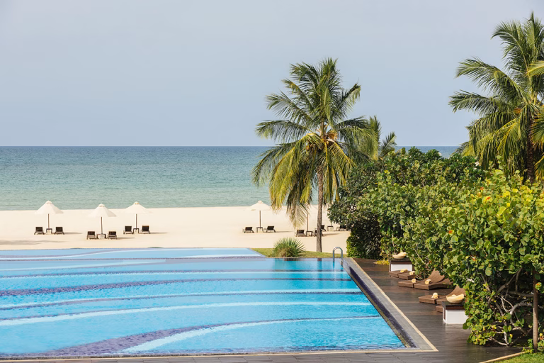 Pool mit Liegestühlen und einem atemberaubenden Ausblick auf das Meer