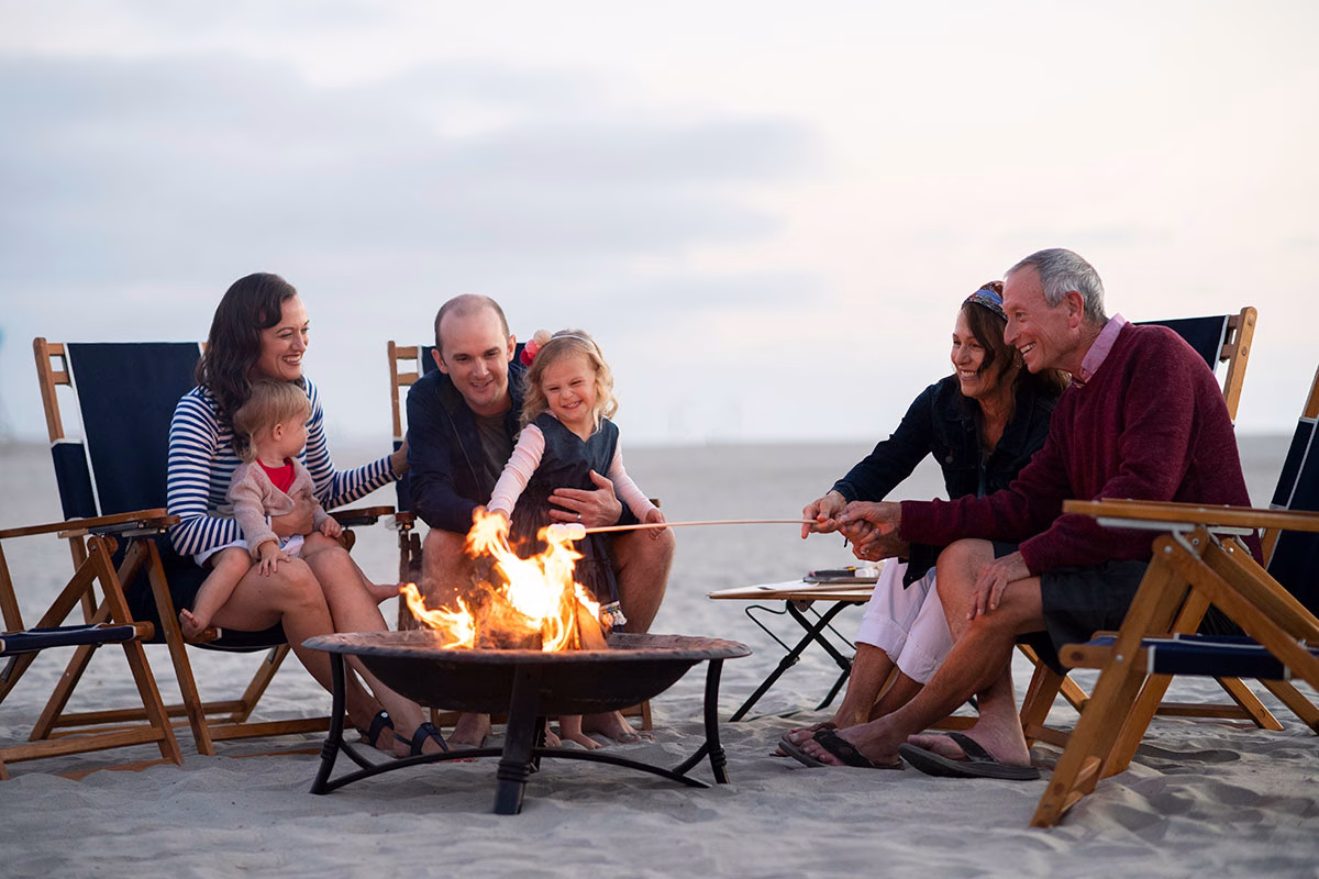 Eine Familie brennt unter einer Feuerstelle Marshmallows an